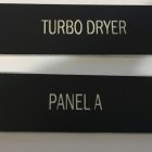 image of Phenolic Label & Wall plate in black background with white lettering