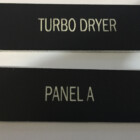 image of Phenolic Label & Wall plate in black background with white lettering